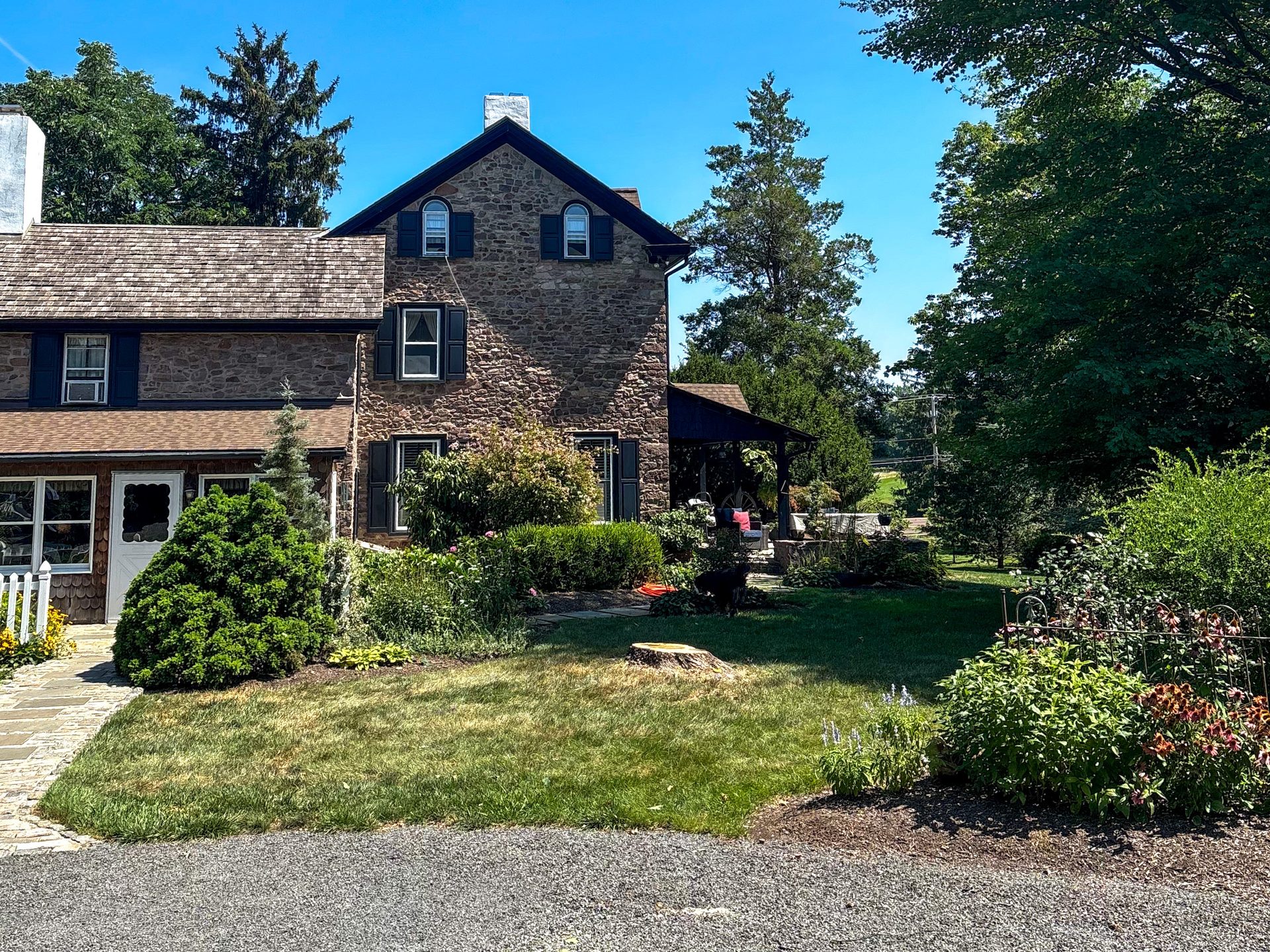 Lawn and planting beds beside the stone house